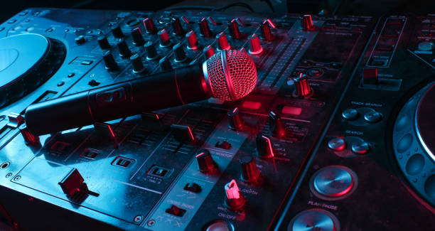 Night club, nightlife concept. Disco. Microphone on DJ remote. Neon red blue light stock photo