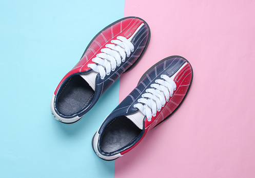 Bowling shoes on a pink-blue pastel background. Top view. Minimalism