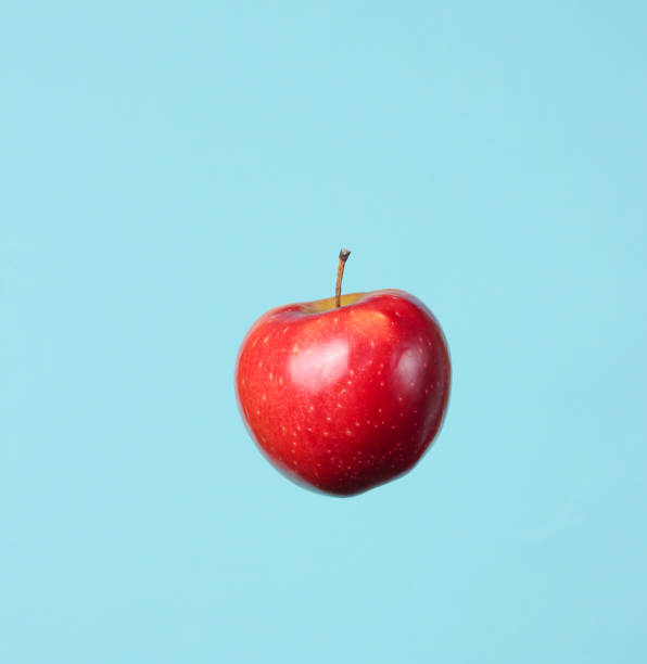 Ripe red apple on a blue background.
