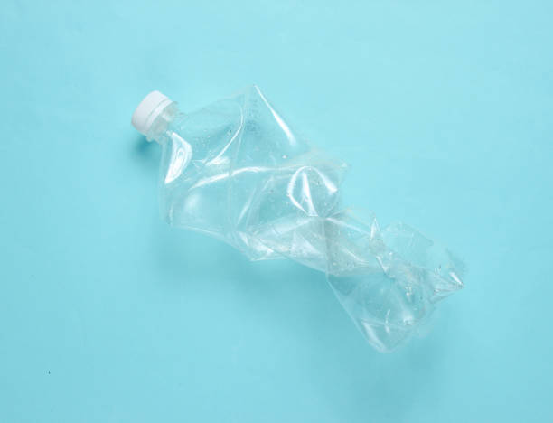 istock Minimalistic ecological concept. Crumpled plastic bottle on blue background. Environmental plastic pollution 1141041704