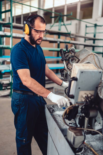 istock Factory worker operating band saw cutting machine 1141044788