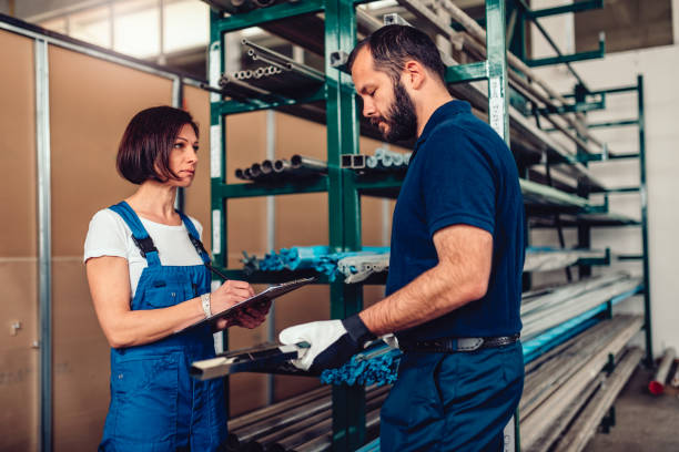 istock Female stock clerk processing purchase order with warehouse worker 1141044875