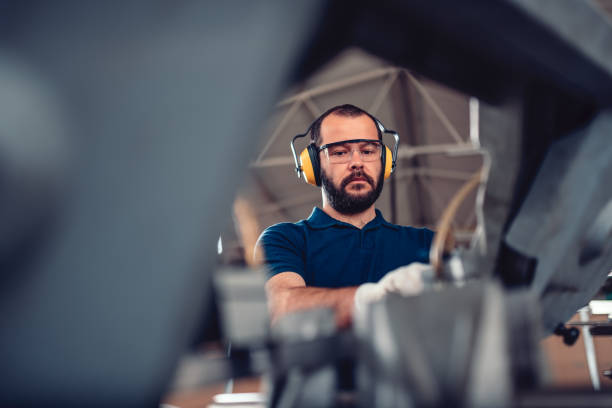 istock Factory worker operating band saw cutting machine 1141046415