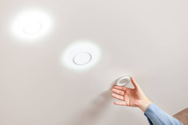 fixing ceiling light. person repairing or replacing ceiling diod light at white background.
