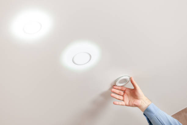 fixing ceiling light. person repairing or replacing ceiling diod light at white background. stock photo