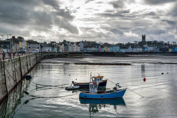 This is Donaghadee Harbour and Lighthouse on the east coast of Northern Ireland.  Fishing boats are anchored in the calm water