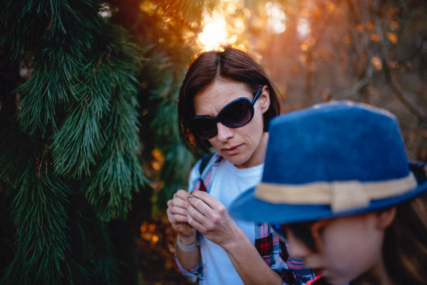 istock Mother and daughter standing by the pine tree at thick forest 1141050207
