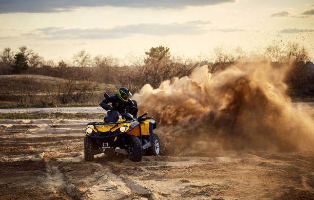 Racing in the sand on a four-wheel drive quad. Racing powerful quad bike on the difficult sand in the summer. west africa coast photos stock pictures, royalty-free photos & images
