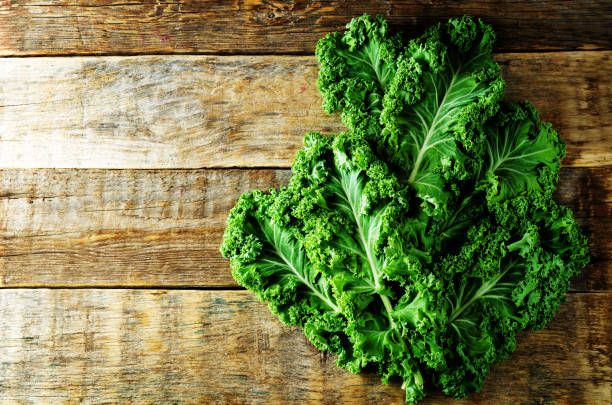 istock Fresh kale Bunch on a dark wood background 1141051585