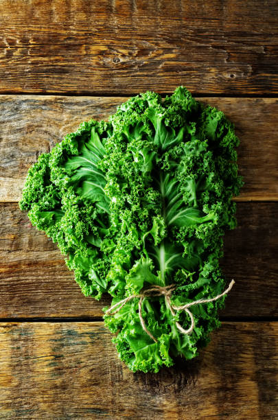 istock Fresh kale Bunch on a dark wood background 1141051607