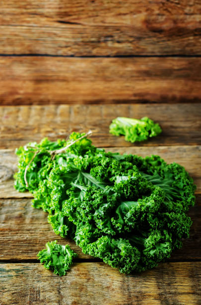 istock Fresh kale Bunch on a dark wood background 1141051620