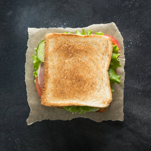istock Sandwich with bacon, tomato, onion, salad on black background. 1141054147