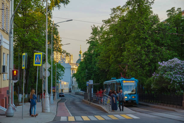Commuters going home with a blue tramcar in the street, MOSCOW, RUSSIA - APRIL 15, 2017