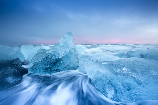 Stunning image of large pieces of 'diamond' like glacier ice washed up by the sea at sunset.
