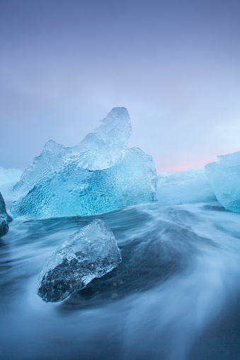 Stunning image of large pieces of 'diamond' like glacier ice washed up by the sea at sunset.