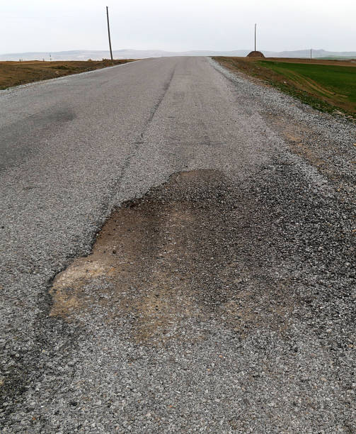 istock degraded asphalt road, pits formed on asphalt road, 1141062492
