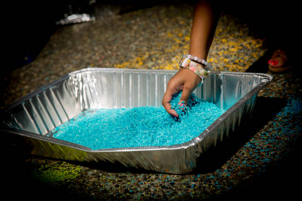 Child hand taking coloured raw rice grains creating traditional Indian artwork Concept creativity youth hand holding bright blue rice grains haldi ceremony stock pictures, royalty-free photos & images