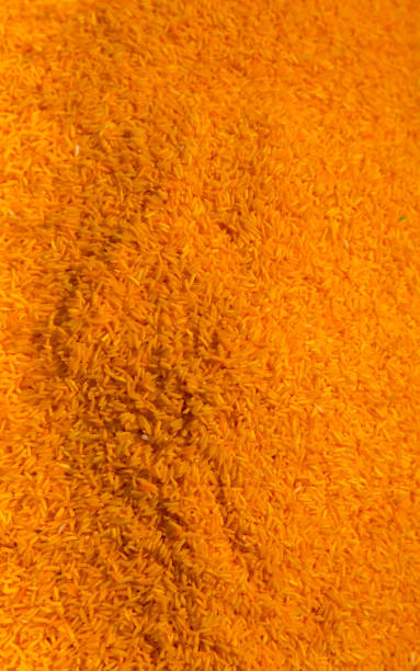 istock Uncooked raw rice grains background orange colour vertical 1141065190