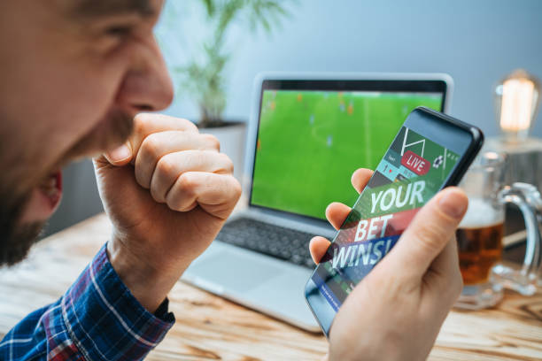 istock Man celebrating victory after making bets at bookmaker website 1141067760