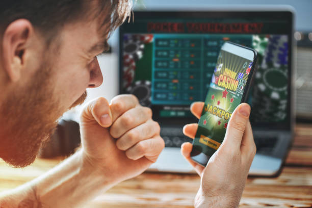 Man celebrating victory after making bets at bookmaker website Lucky man celebrating victory after getting jackpot in online casino. Poker tournament on the laptop screen on the background. Online Poker stock pictures, royalty-free photos & images