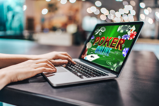 Close up cropped photo of girl hands using her laptop for playing poker online.