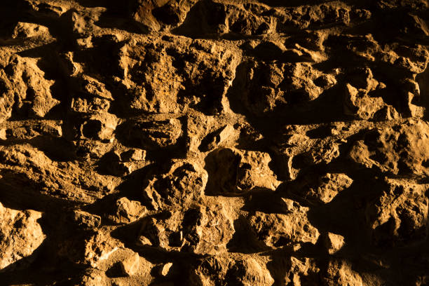 Light and shade make patterns on a stone wall in the Cotswolds. The walls are made with limestone and use no mortar or cement.