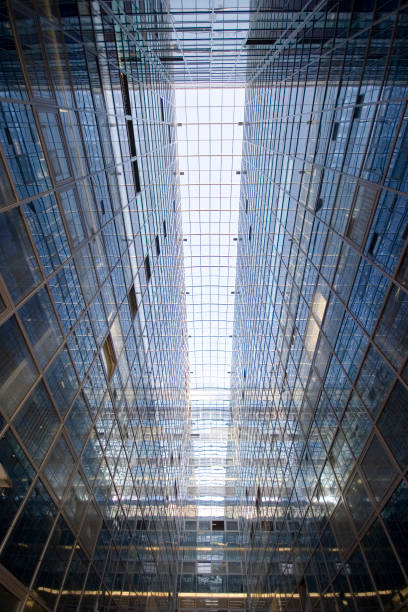istock Perspective and underside angle abstract view to textured background of modern glass office building 1141071510
