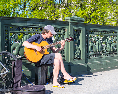 Berlin Germany - April 21. 2018: Man sitting on a bridge and playing guitar
