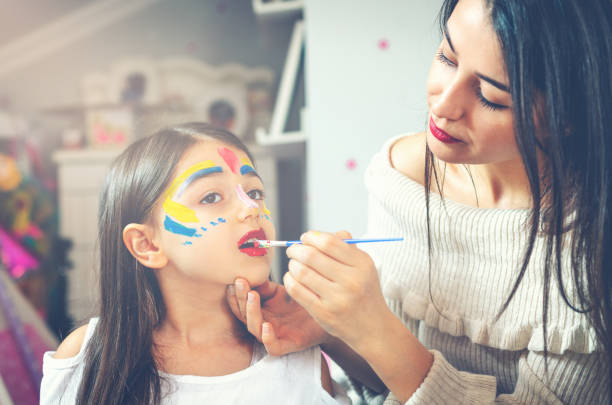 istock Young mother painting daughters face 1141074554