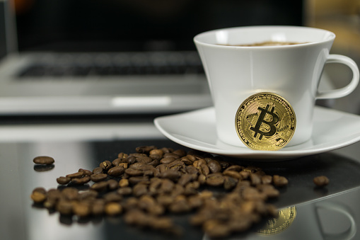 Photo of Bitcoin cryptocurrency coin with coffee cup and coffee beans