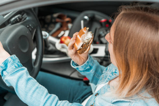 istock Holding a steering wheel and holding a burger 1141083347