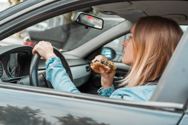 istock Woman eating while driving with opened window 1141083440