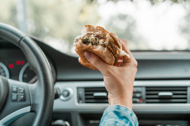 istock Holding a bitten burger in the car 1141083704