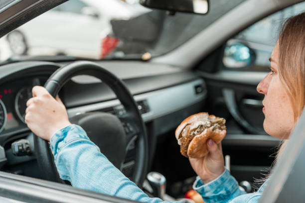 istock Woman holding a burger while driving 1141083755