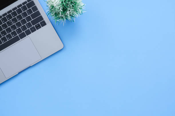 istock Office desk working space - Flat lay top view copy space of a working space with laptop placing on a blue pastel background with blank space. Pastel blue color copy space working desk concept. 1141093579