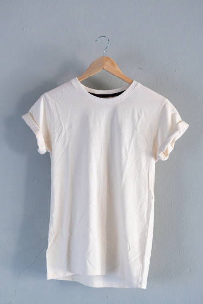 istock Retro fold white cotton T-Shirt clothes mock up template on gray cement background concept for retail dress shop backdrop, Blank flat lay vintage grey wall plain laundry advertising 1141094302