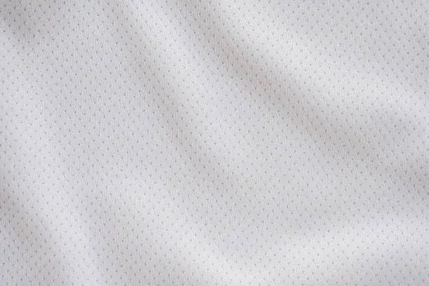 Photo of White fabric sport clothing football jersey with air mesh texture background