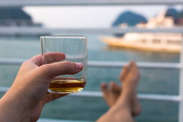 istock Tourist sailing on a boat with a drink in hand. 1141094681
