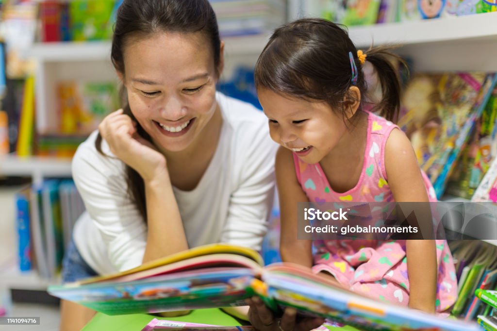 Eltern und Kinder lesen Bücher gemeinsam in der Bibliothek. - Lizenzfrei Lesen Stock-Foto