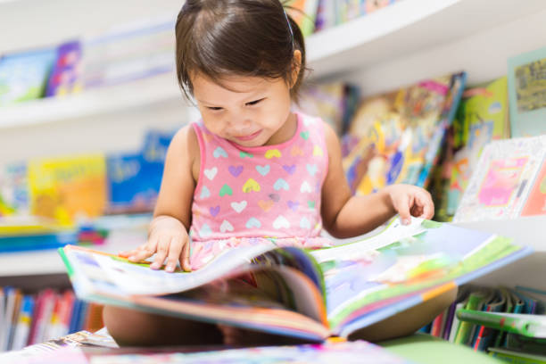 petite fille lisant un livre. éducation. - baby book toddler reading photos et images de collection