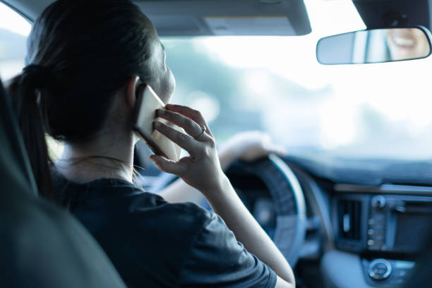 parlare al telefono mentre si guida. sms e guida. autista distratto al volante. - driving text messaging accident danger foto e immagini stock