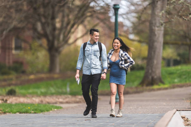 istock Cute Asian couple looking at a map as they walk through a park 1141096009