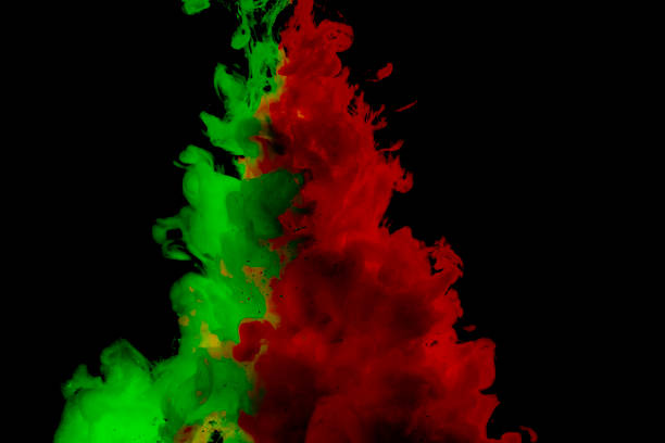 istock Green and red colored abstract acrylic paint spraiyng on a black background. 1141096090