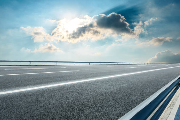 istock Asphalt road ground and blue sky with white clouds scene 1141097455