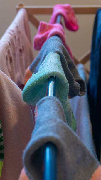 istock Single ankle sock mismatched with sock pairs drying on laundry rack after washing. Depicting missing socks, sock pairs, laundry day, chores, domestic life, etc. 1141098572