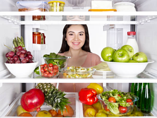 istock Young woman looking inside the fridge 1141098665