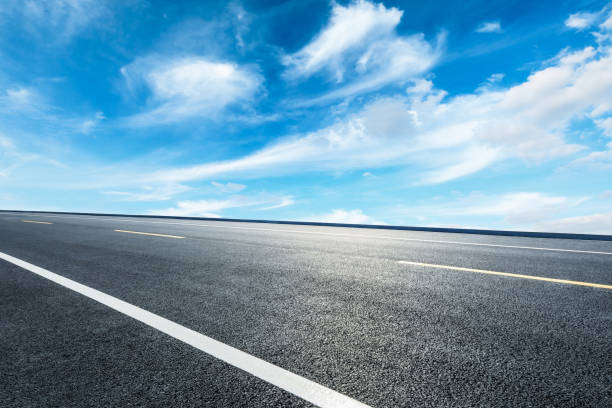 istock Asphalt road ground and blue sky with white clouds scene 1141098811