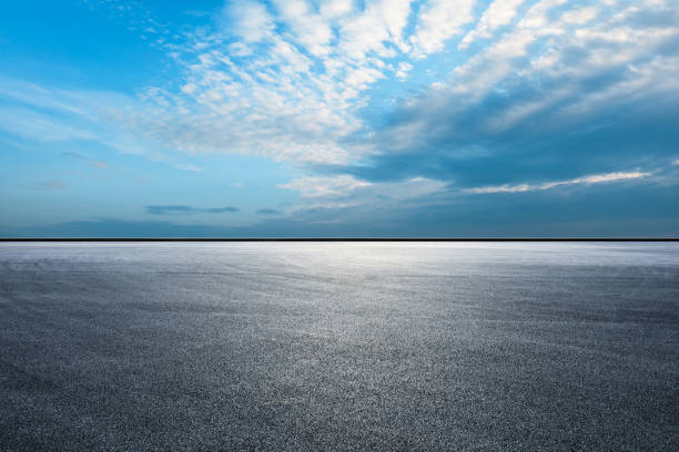 terrain d’asphalte de piste de course et de beaux nuages de ciel - road horizon highway speed photos et images de collection