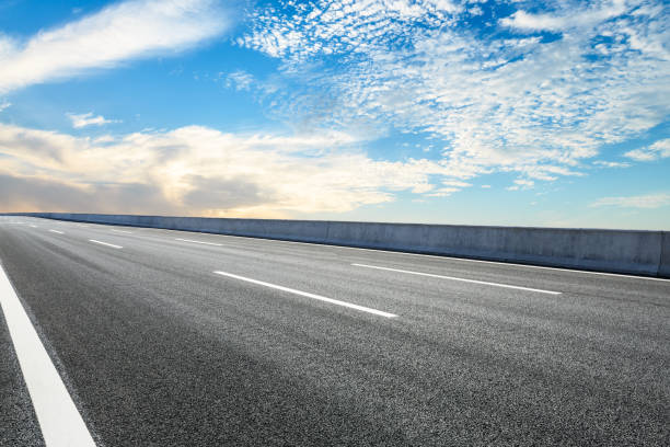 istock Asphalt road ground and blue sky with white clouds scene 1141098903