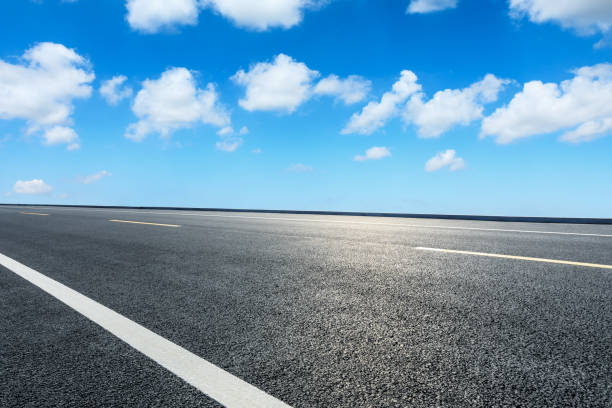 istock Asphalt road ground and blue sky with white clouds scene 1141100558